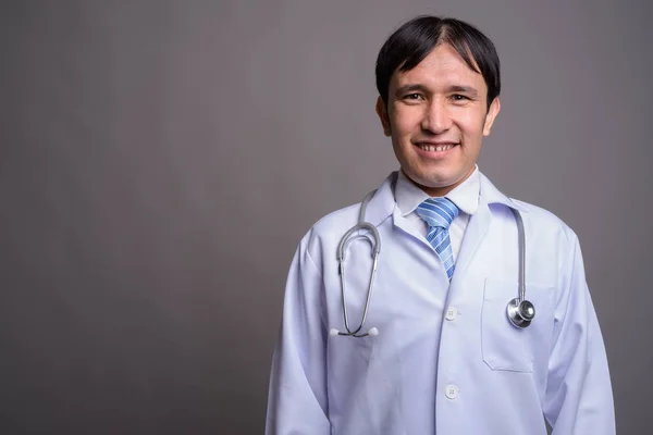 Jovem asiático homem médico contra fundo cinza — Fotografia de Stock