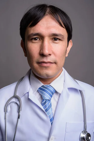 Лікар - молодий азіат проти сірого походження — стокове фото