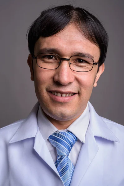 Pemuda Asia dokter memakai kacamata terhadap backgroun abu-abu — Stok Foto