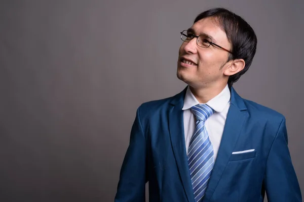 Ritratto di giovane uomo d'affari asiatico su sfondo grigio — Foto Stock