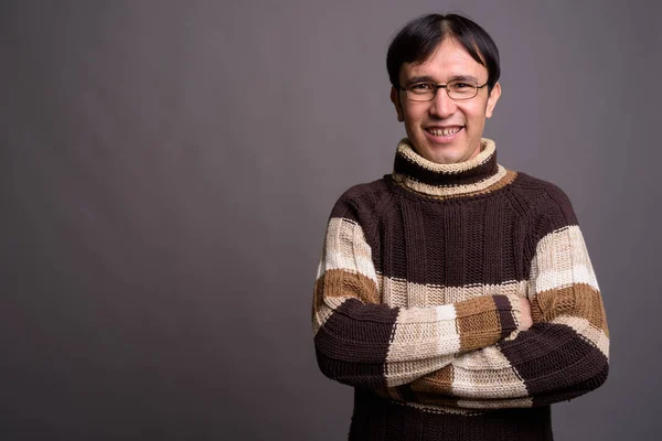 Jovem ásia nerd homem vestindo gola alta suéter contra cinza bac — Fotografia de Stock