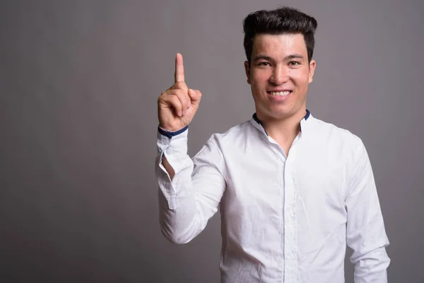 Retrato de joven empresario asiático sobre fondo gris — Foto de Stock