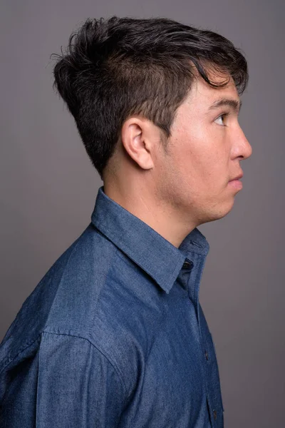 Joven asiático vistiendo camisa azul sobre fondo gris — Foto de Stock