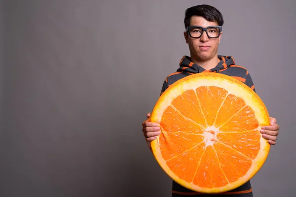 Joven asiático nerd hombre usando sudadera con capucha contra gris fondo —  Fotos de Stock