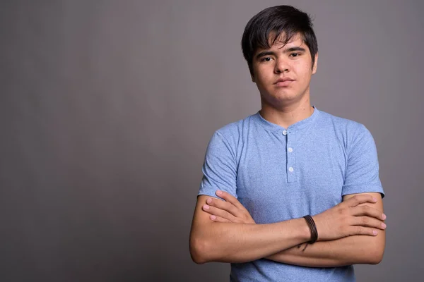 Fiatal ázsiai tizenéves fiú ellen szürke háttérb kék inget visel — Stock Fotó