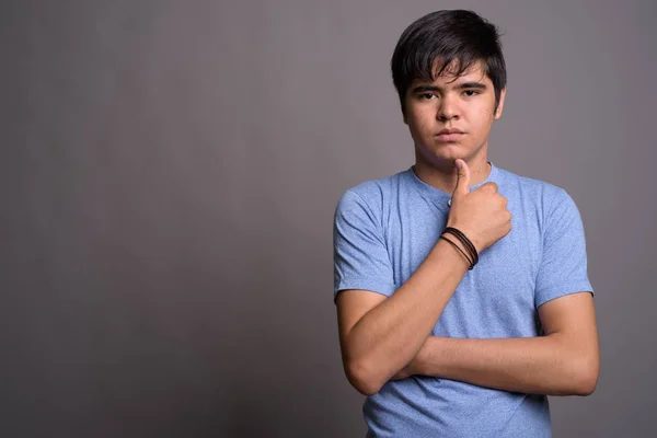 Joven adolescente asiático vistiendo camisa azul contra fondo gris —  Fotos de Stock