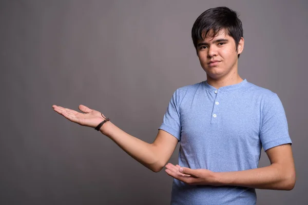 Νέοι Ασιατικές εφηβικό αγόρι που φοράει μπλε πουκάμισο εναντίον γκρι λεμονάτα — Φωτογραφία Αρχείου
