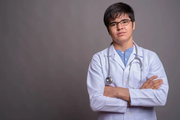 Joven asiático hombre médico contra gris fondo — Foto de Stock