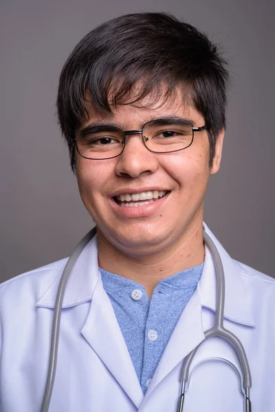 Joven asiático hombre médico contra gris fondo — Foto de Stock