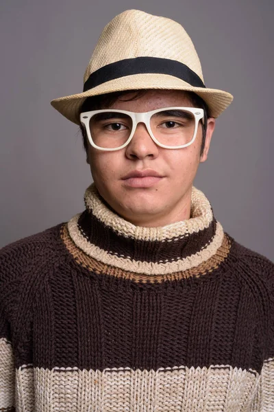 Elegante giovane ragazzo asiatico adolescente che indossa abiti caldi contro gr — Foto Stock