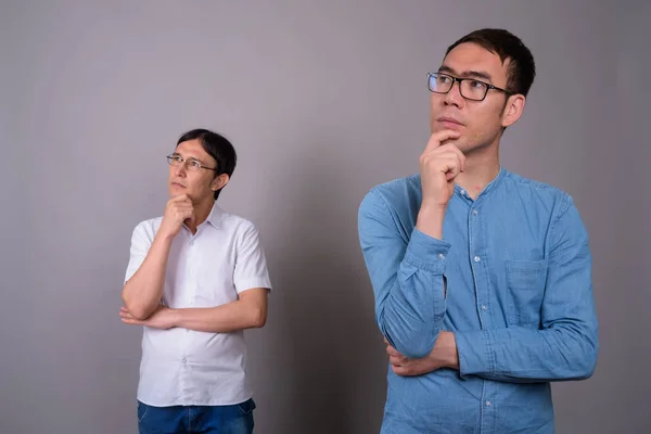 Deux jeunes hommes d'affaires asiatiques portant des lunettes ensemble contre — Photo