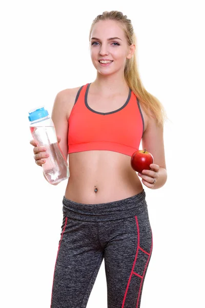 Młody szczęśliwy nastolatkę uśmiechający się trzymając butelkę wody i — Zdjęcie stockowe