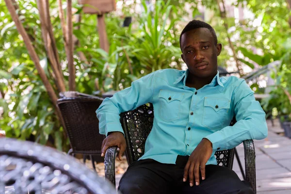 Joven hombre africano negro sentado en la cafetería al aire libre jalá —  Fotos de Stock