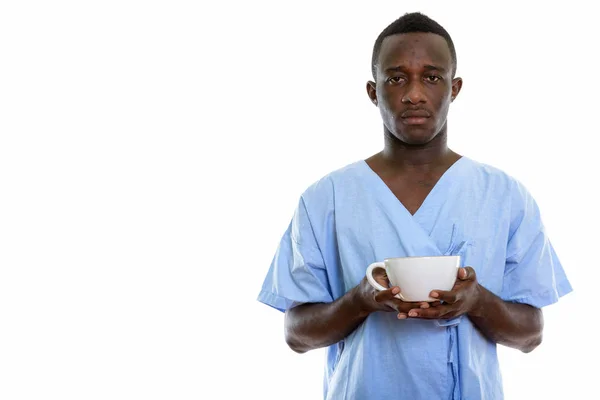 Estudio disparo de joven negro africano hombre paciente celebración de café cu —  Fotos de Stock