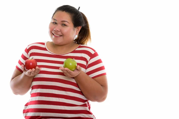 Studio shot of young happy fat Asian woman smiling while holding — Stock Photo, Image