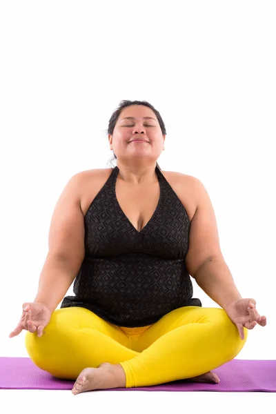 Studio shot de joven gorda asiática meditando con los ojos cerrados —  Fotos de Stock