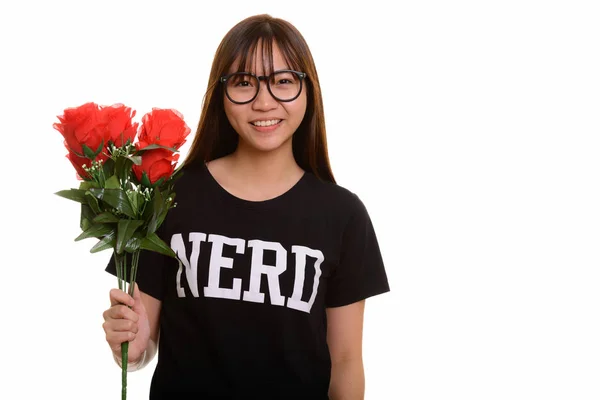 Giovane felice nerd asiatico adolescente sorridente e tenendo rosa rossa — Foto Stock