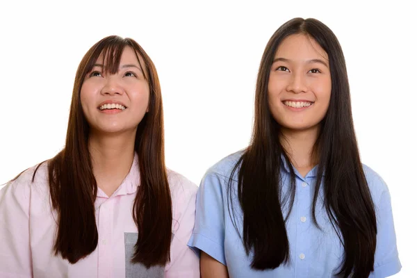 Twee jong gelukkig aziatisch tiener meisjes glimlachen en denken — Stockfoto