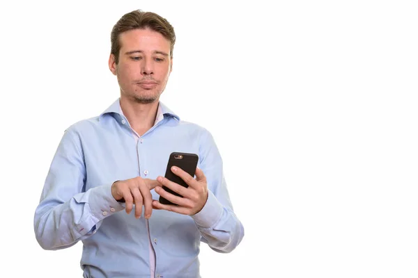 Handsome serious Caucasian businessman using mobile phone — Stock Photo, Image