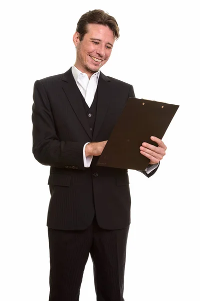 Happy Caucasian businessman reading clipboard while smiling — Stock Photo, Image