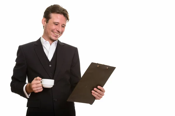 Empresário caucasiano feliz lendo prancheta enquanto segurando coff — Fotografia de Stock