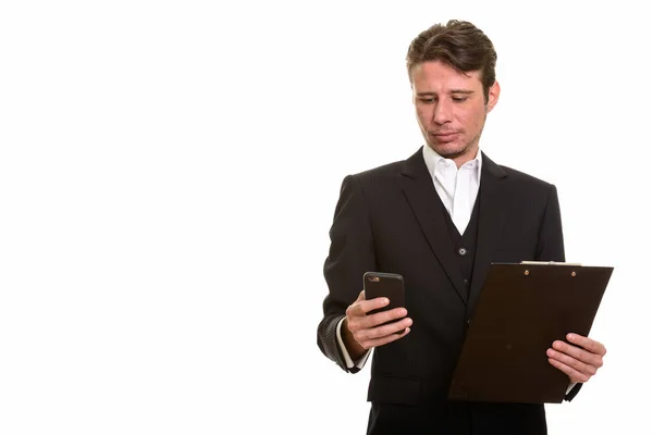 Handsome Caucasian businessman using mobile phone while holding — Stock Photo, Image