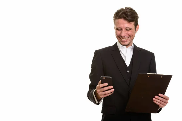 Happy Caucasian businessman using mobile phone while holding cli — Stock Photo, Image
