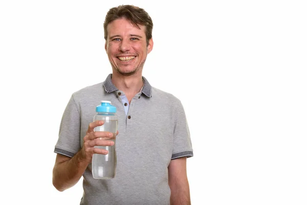 Feliz hombre caucásico sosteniendo botella de agua mientras sonríe — Foto de Stock