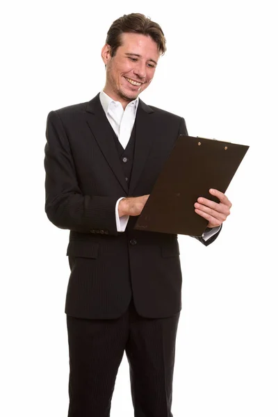 Happy Caucasian businessman reading clipboard while smiling Stock Image