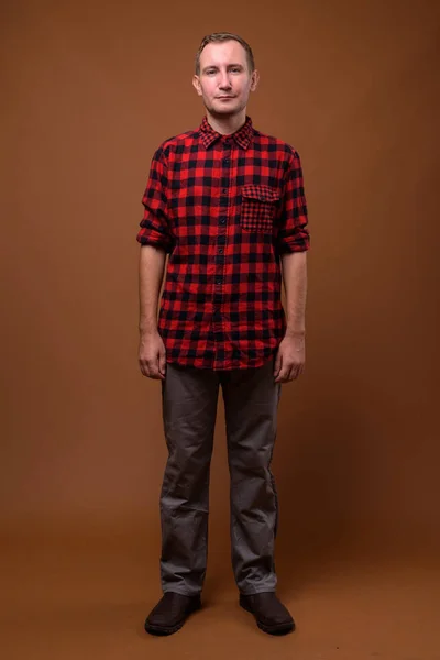 Studio shot of man against brown background — Stock Photo, Image