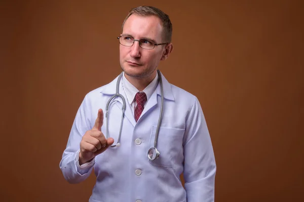 Estudio de hombre médico sobre fondo marrón —  Fotos de Stock