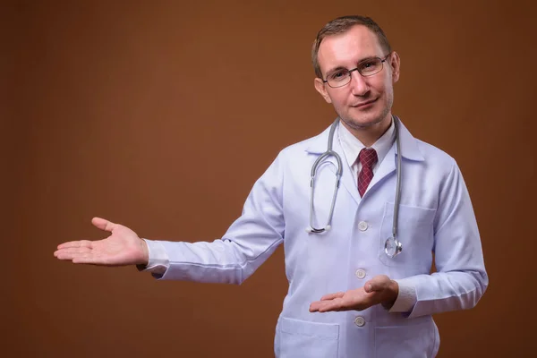 Estudio de hombre médico sobre fondo marrón — Foto de Stock