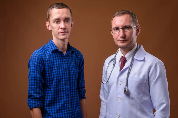 男医師と茶色の背景に対して若い男性患者 — ストック写真