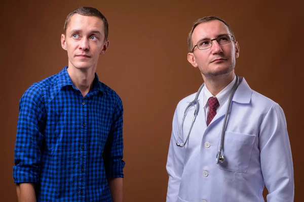 男医師と茶色の背景に対して若い男性患者 — ストック写真