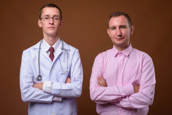 若い男の医者と茶色の背景に男性患者 — ストック写真