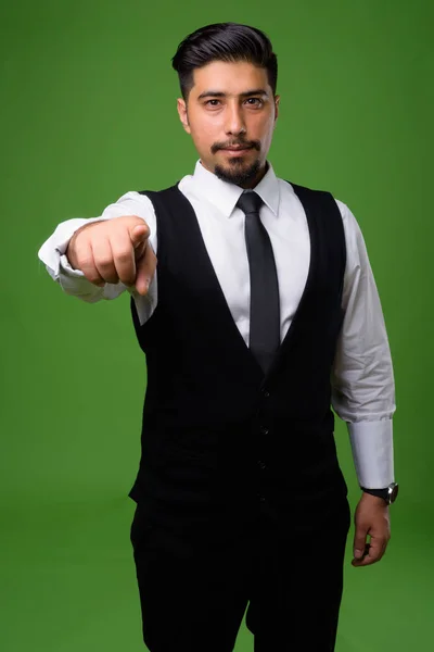 Young bearded Iranian businessman against green background — Stock Photo, Image