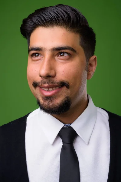 Young bearded Iranian businessman against green background — Stock Photo, Image