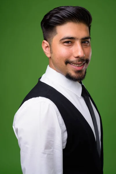 Fiatal szakállas iráni üzletember zöld háttérrel — Stock Fotó