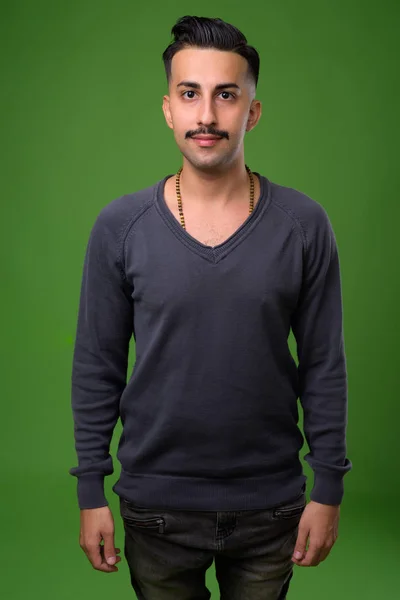 Ung snygg iranska man med mustasch mot gröna bak — Stockfoto