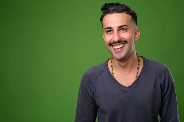 Joven hombre iraní guapo con bigote contra fondo verde — Foto de Stock