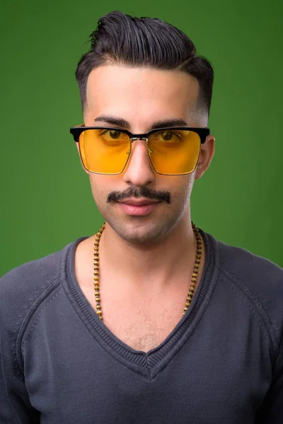 Jeune homme iranien beau avec moustache contre fond vert — Photo