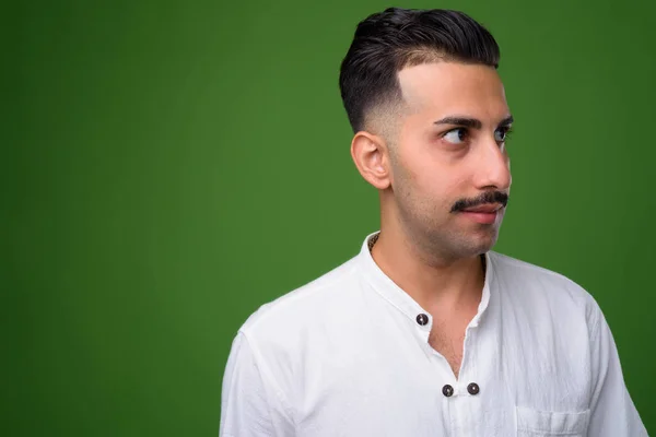 Ung snygg iranska man med mustasch mot gröna bak — Stockfoto