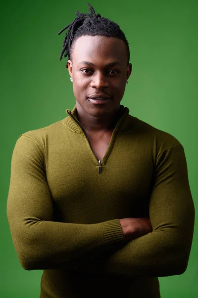 Молодой красивый африканский мужчина из Кении на зеленом фоне — стоковое фото