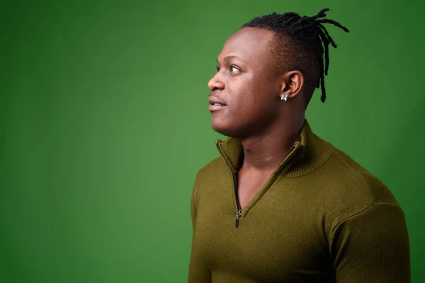 Junger schöner afrikanischer Mann aus Kenia vor grünem Hintergrund — Stockfoto