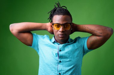 Kenyalı yakışıklı Afrikalı genç adam yeşil arka plana karşı