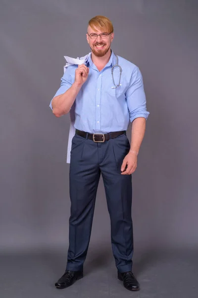 Бородатый врач со светлыми волосами на сером фоне — стоковое фото