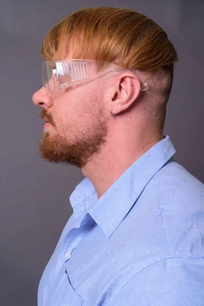 Bearded man doctor with blond hair wearing protective glasses ag — Stock Photo, Image