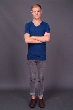 Gri arka planda genç yakışıklı bir adamın portresi