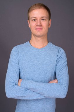 Gri arka planda genç yakışıklı bir adamın portresi