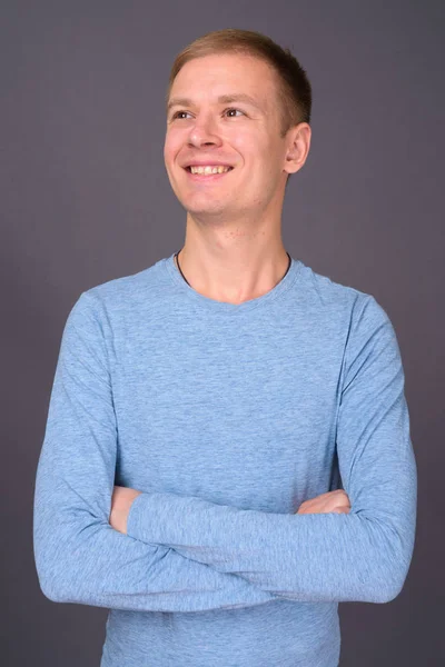 Retrato de un joven guapo sobre fondo gris — Foto de Stock